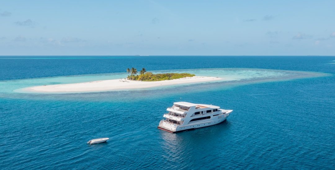 Liveaboard boat cruising over turquoise Maldivian water